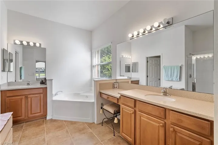 Bathroom with plus walk in shower, double vanity, and tile patterned floors