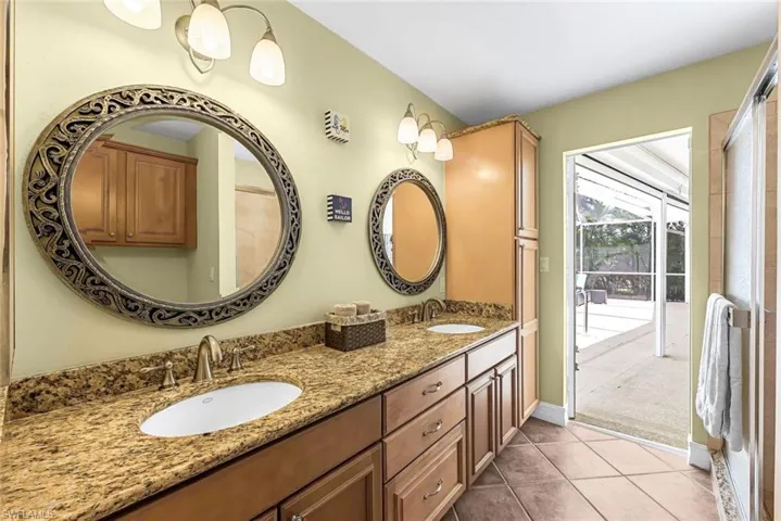 Bathroom featuring tile patterned floors and dual bowl vanity
