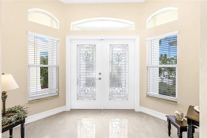 Entryway with light tile patterned flooring and french doors