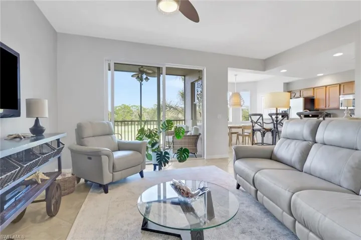 Living room with light tile patterned floors, ceiling fan, and recessed lighting