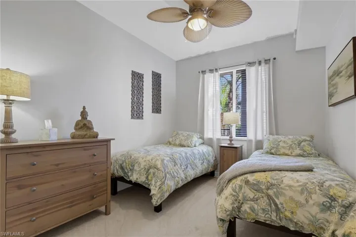 Guest bedroom featuring light colored carpet and ceiling fan