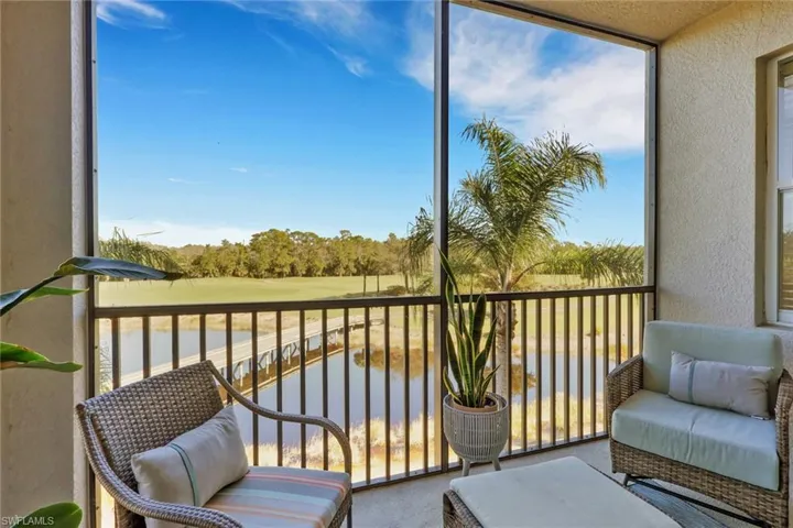 Sunroom featuring view of golf course and view of scattered trees
