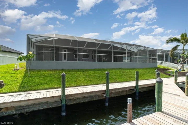 Rear view of house with a water view, dock, Captain's walk.