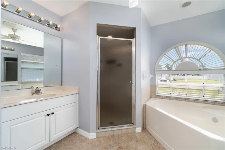 Primary bathroom, stall shower, garden tub, and vanity.