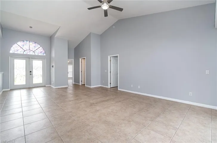 Foyer with high vaulted ceiling, ceiling fan, light tile patterned flooring