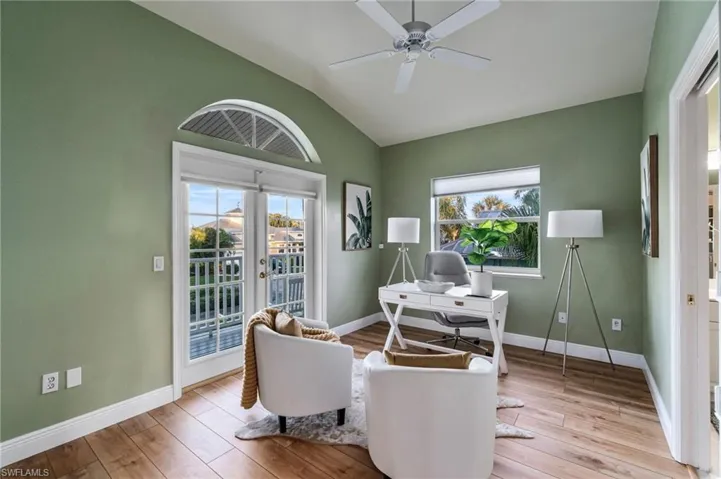 Home office with light wood-style floors, healthy amount of natural light, french doors, and high vaulted ceiling