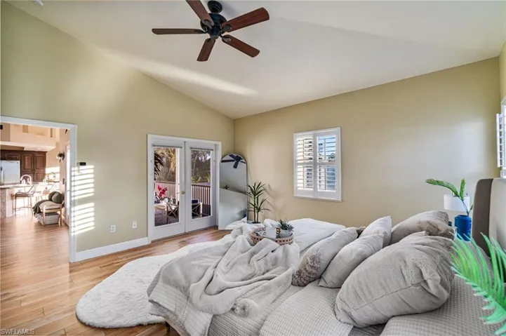 Primary Bedroom with french doors out to the screened in 2nd story lanai with waterfront views on 2 sides.  Spacious vaulted ceilings.