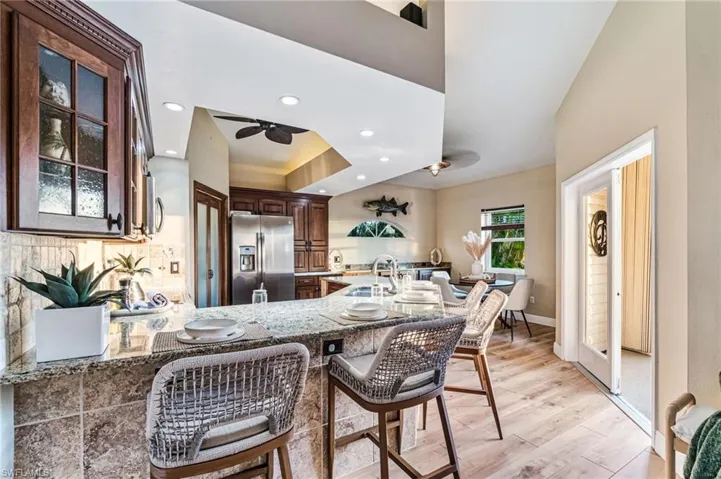 Open kitchen with island seating for casual dining, and eat-in dining area for more formal meals - all opening up to screened in lanai overlooking the canal