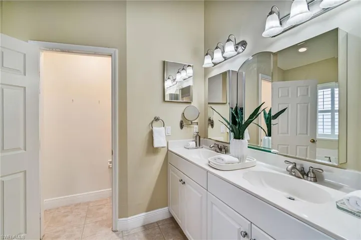 Full bathroom with double vanity and light tile patterned floors