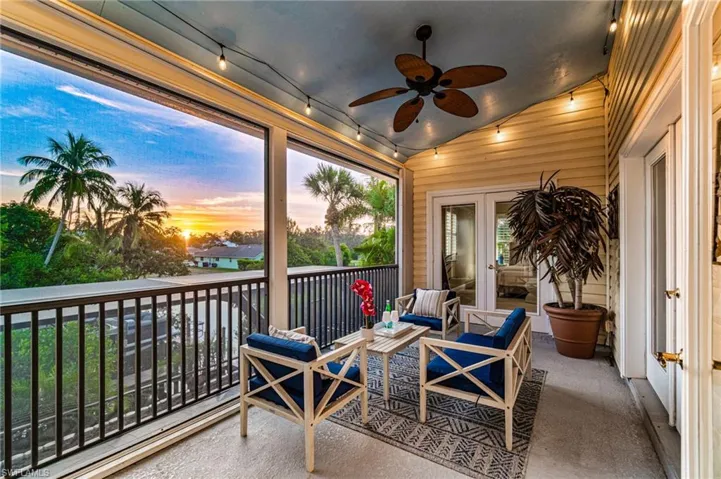 Sunroom / solarium featuring lofted ceiling, wooden walls, and carpet flooring
