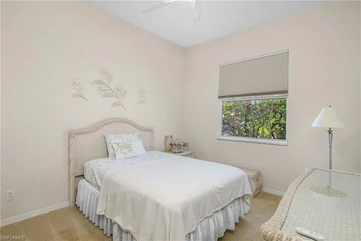 Bedroom with ceiling fan and light carpet