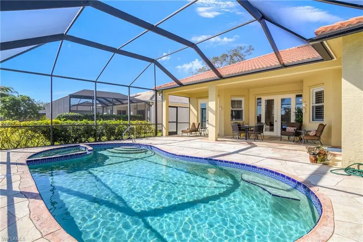 View of swimming pool featuring a lanai, an in ground hot tub, a patio, and french doors