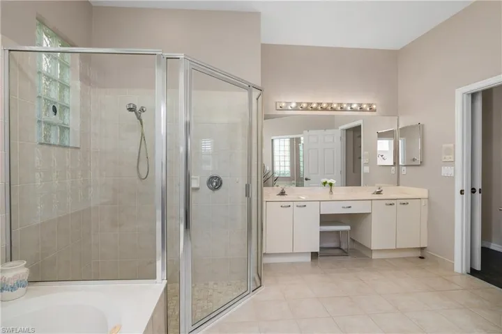 Bathroom with vanity, a wealth of natural light, and plus walk in shower