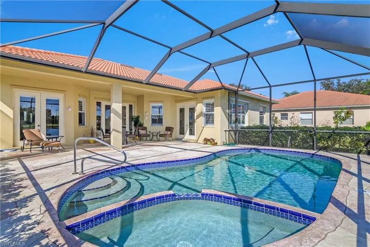 View of pool featuring an in ground hot tub, french doors, a patio, and glass enclosure