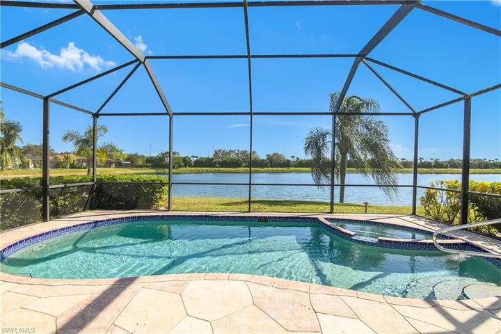 View of swimming pool featuring a lanai, an in ground hot tub, and a water view