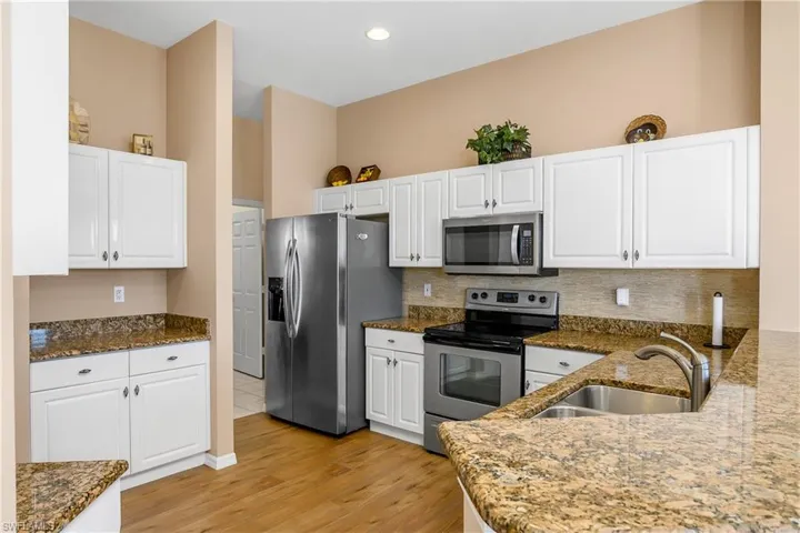 Kitchen featuring white cabinets, light hardwood / wood-style floors, sink, and stainless steel appliances