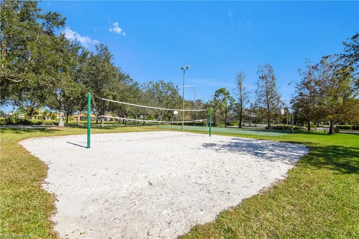 View of home's community featuring volleyball court and a yard