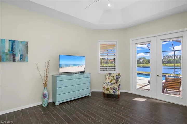 Living area with french doors, a healthy amount of sunlight, and dark hardwood / wood-style floors