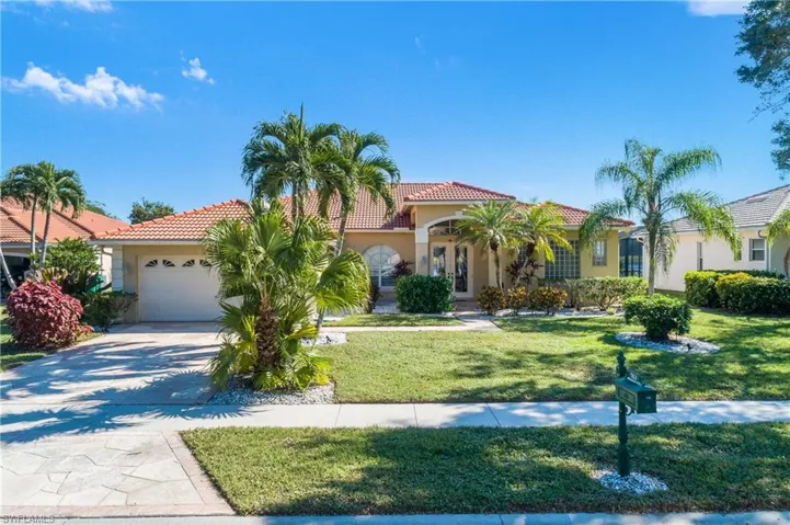 Mediterranean / spanish-style home with a front yard and a garage