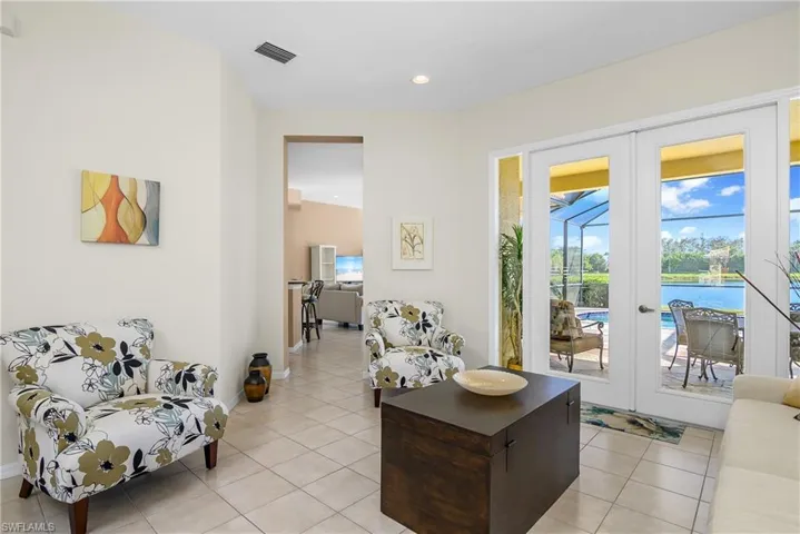 Tiled living room featuring french doors and a water view