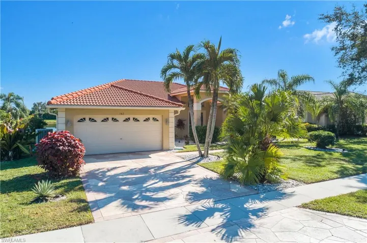 Mediterranean / spanish-style home with a front lawn and a garage