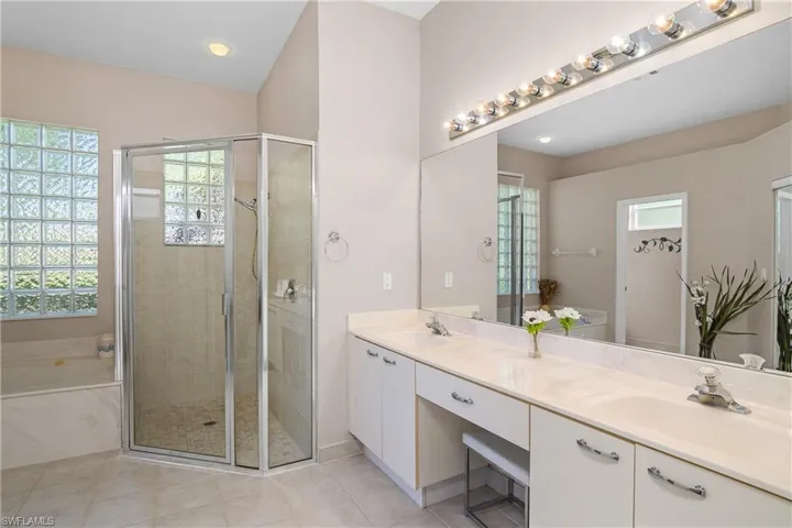 Bathroom with tile patterned floors, vanity, a healthy amount of sunlight, and plus walk in shower