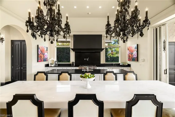 Dining area with a chandelier, arched walkways, plenty of natural light, recessed lighting, and crown molding