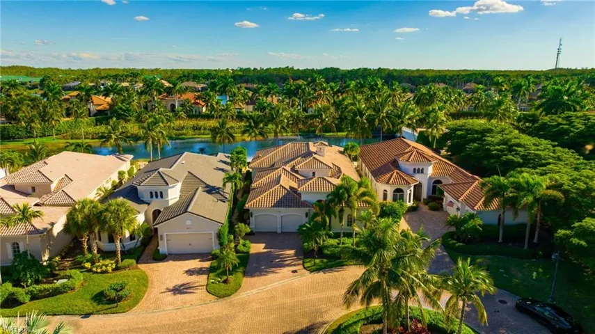Aerial perspective of suburban area featuring a large body of water and a tree filled landscape