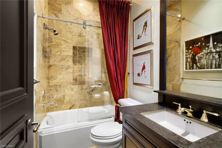 Bathroom with combined bath / shower with glass door and vanity