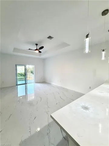 Unfurnished room with a raised ceiling and a ceiling fan