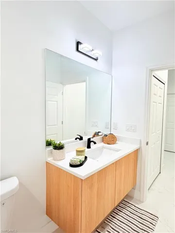 Bathroom with vanity and light marble finish floors