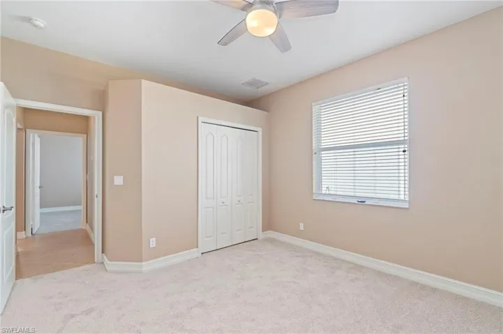 Unfurnished bedroom with light carpet, a closet, and ceiling fan