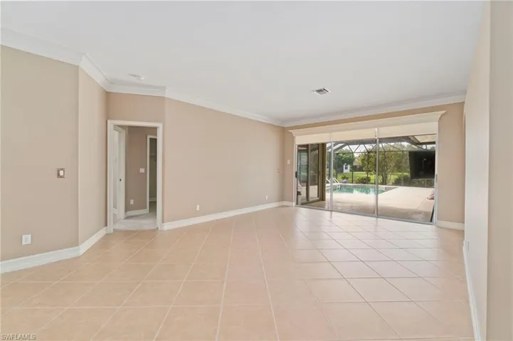 Unfurnished room with ornamental molding, light tile patterned floors, and a sunroom