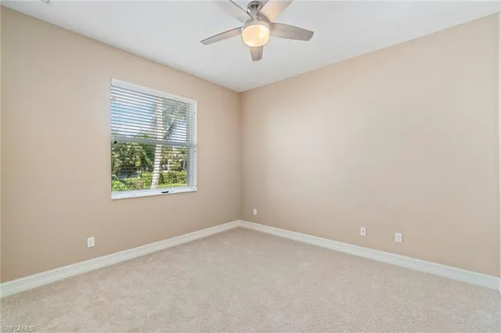 Empty room with light carpet and ceiling fan