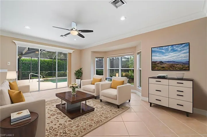 Living area featuring light tile patterned floors, ceiling fan, ornamental molding, and recessed lighting