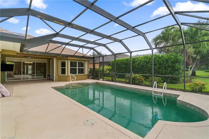 Outdoor pool featuring a patio and glass enclosure