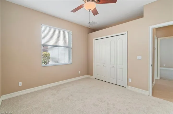 Unfurnished bedroom with light carpet, a closet, and ceiling fan