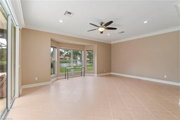 Spare room featuring ceiling fan, light tile patterned flooring, a water view, crown molding, and recessed lighting