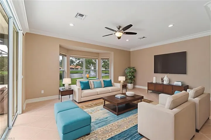 Living area featuring light tile patterned floors, ceiling fan, ornamental molding, and recessed lighting