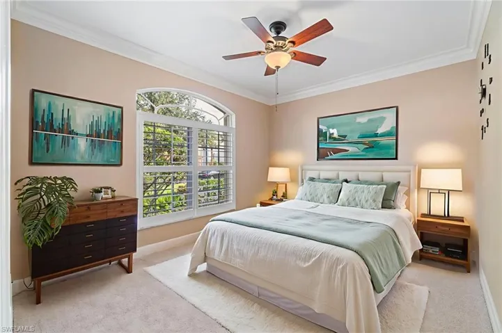 Bedroom featuring carpet floors, ornamental molding, and ceiling fan