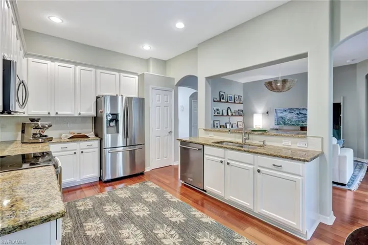 Spacious kitchen with white cabinets, granite counters and stainless appliances.