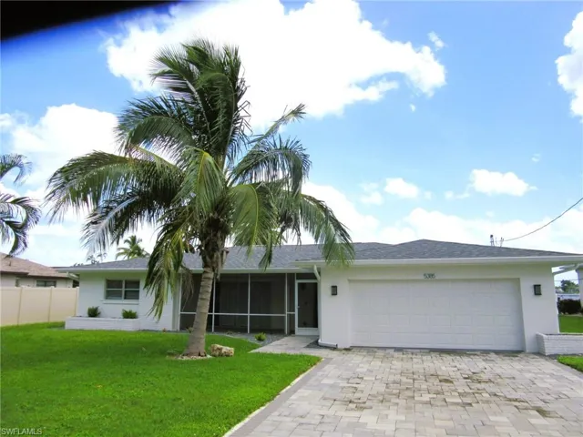 Ranch-style house featuring a garage and a front lawn