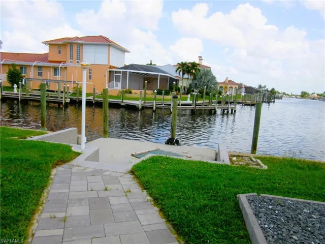 Dock area featuring a lanai, a yard, and a water view
