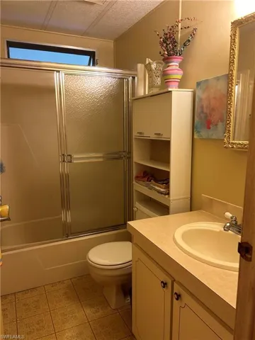 Full bathroom featuring a wealth of natural light, toilet, vanity, and enclosed tub / shower combo