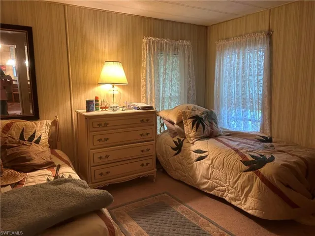 Bedroom featuring carpet floors and wooden walls