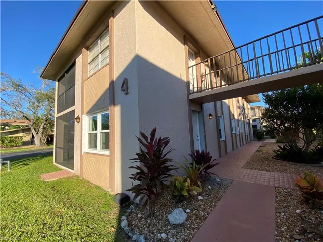 View of home's exterior featuring stucco siding, a balcony, and a yard