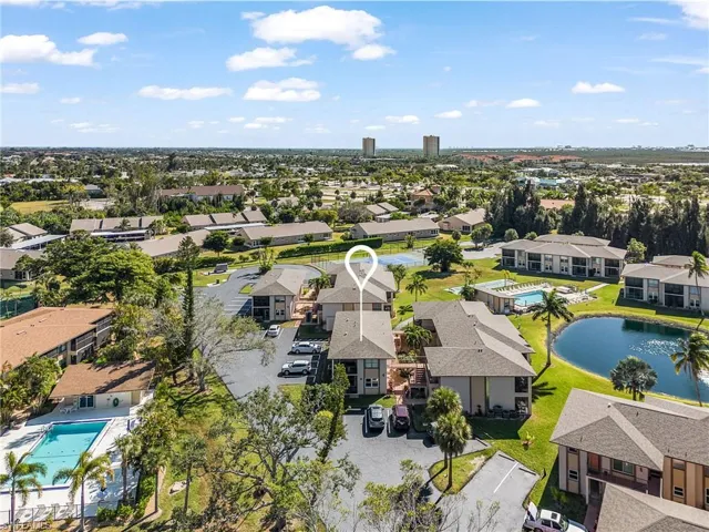 Aerial view of residential area featuring a large body of water and a pool