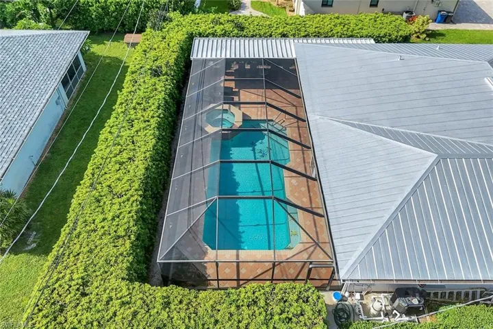 Desirable metal roof and privacy hedge.