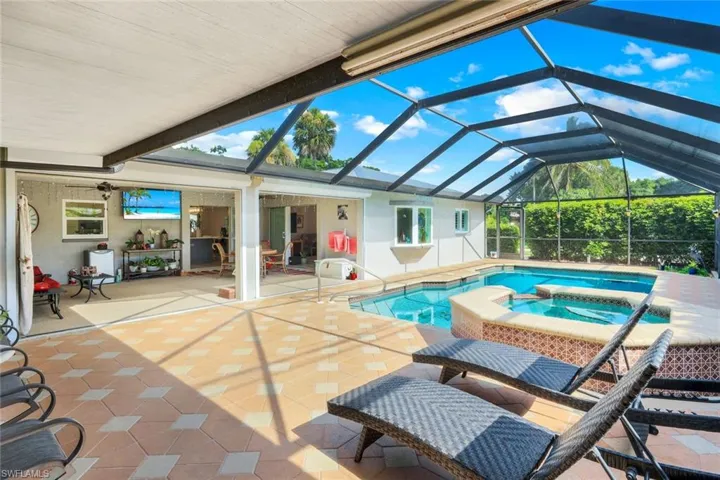 Well-maintained pool area with new screens in pool cage.