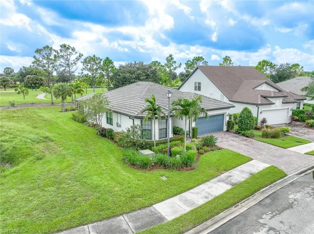 View of front of home with a garage and a front lawn